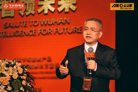 Man speaking at an event with red decoration